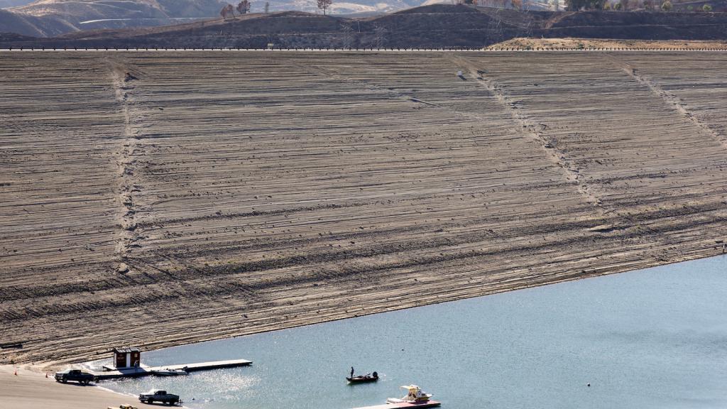 A person boats in the Castaic Lake reservoir in Los Angeles County, with hills scorched by the recent Route Fire in the distance, on October 4, 2022 in Castaic, California.