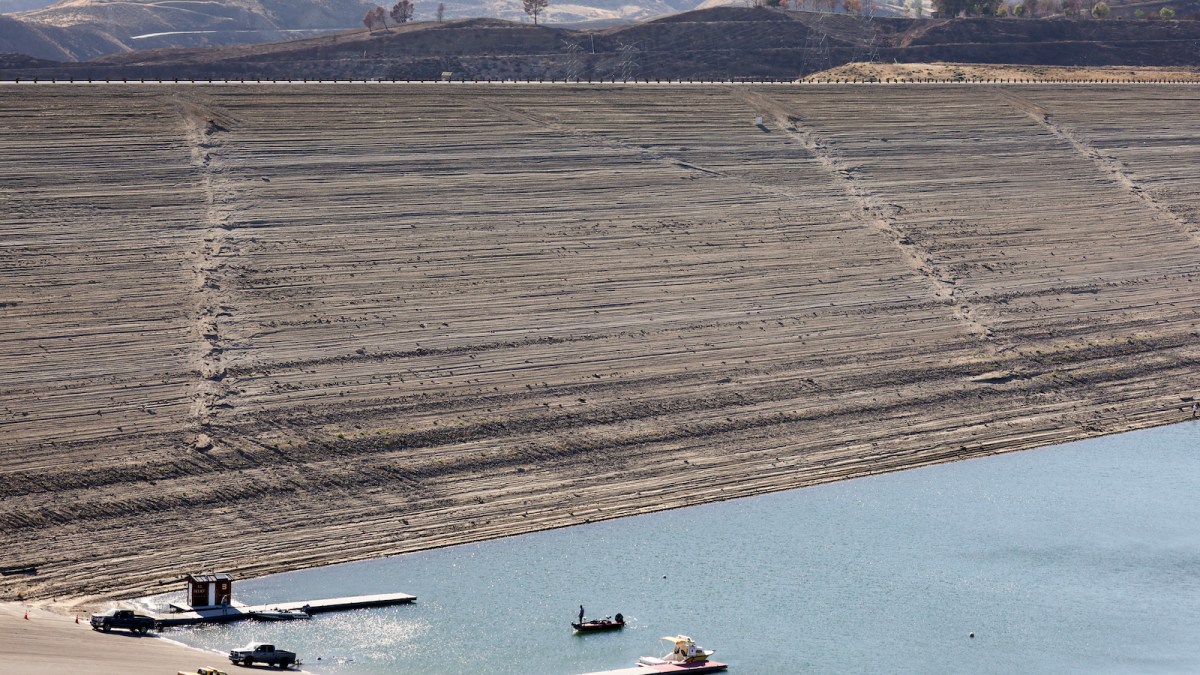 A person boats in the Castaic Lake reservoir in Los Angeles County, with hills scorched by the recent Route Fire in the distance, on October 4, 2022 in Castaic, California.