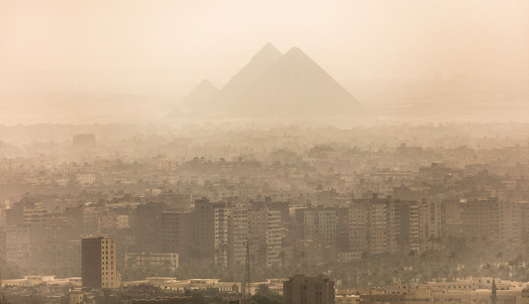 The Giza Pyramids rise above the buildings of Giza on September