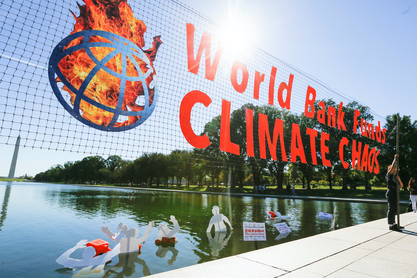 a banner says world bank causes climate chaos