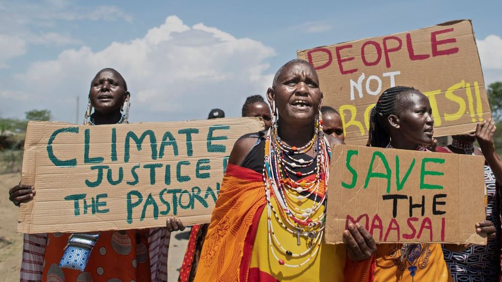 Women from the Masai community hold climate protest signs