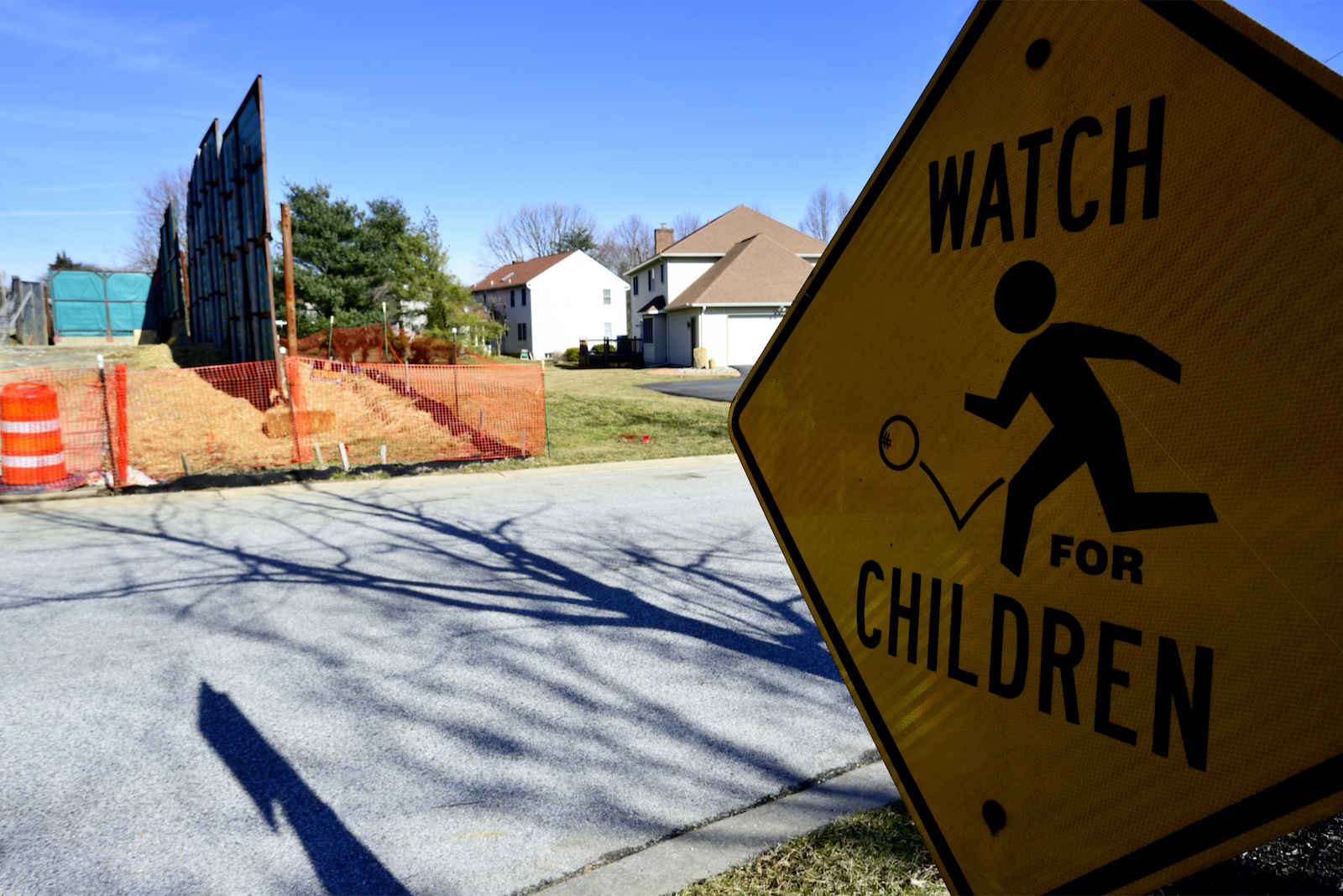 a sign says watch children near construction in a street