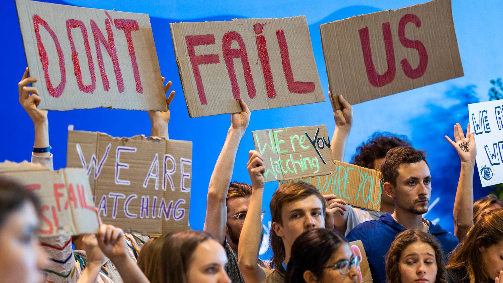 young people holding a sign that says don't fail us