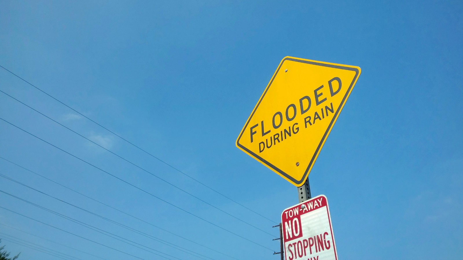Yellow caution sign in California warning of flood zone due to rain