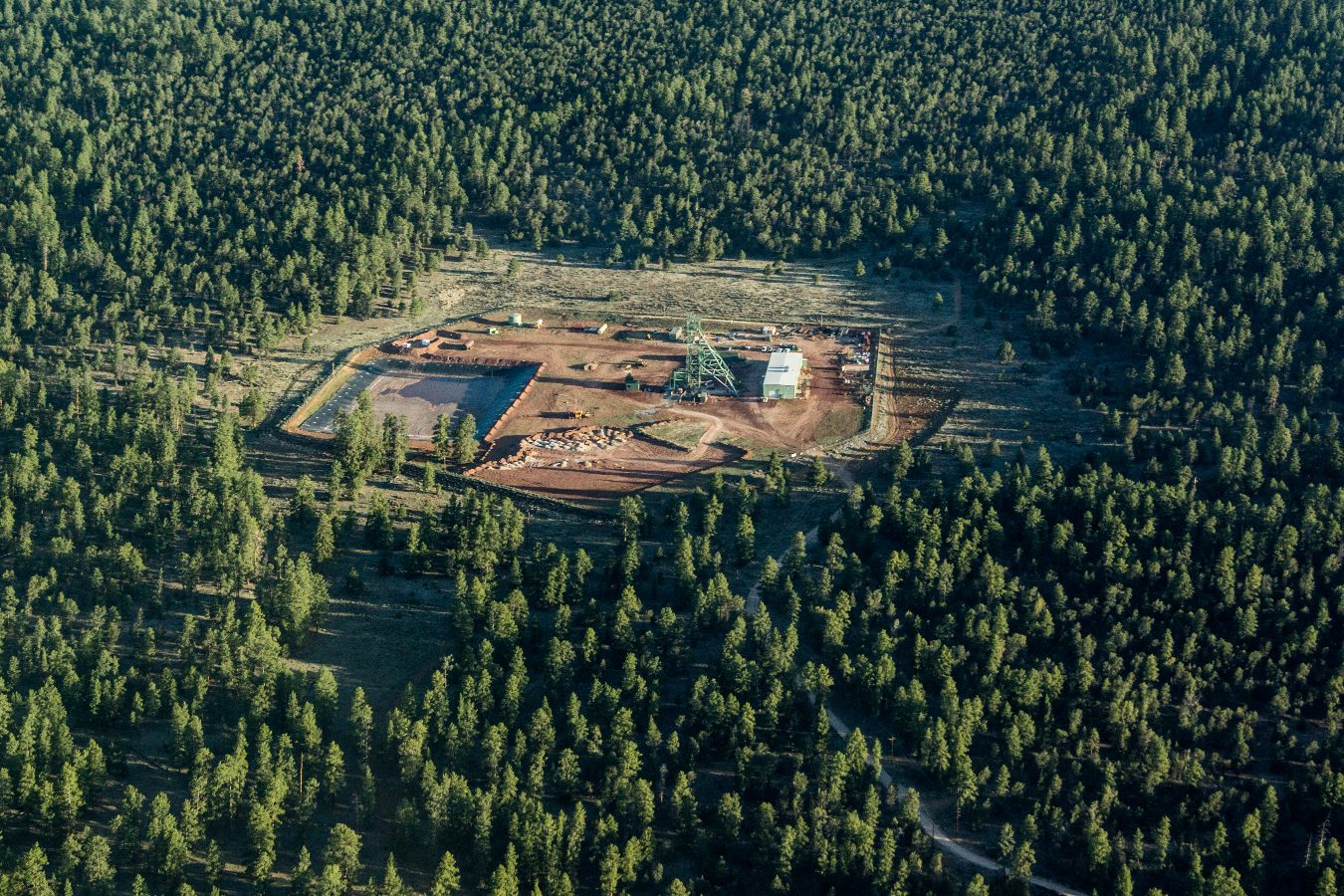 An aerial view of a uranium mine in the middle of a dense forest.