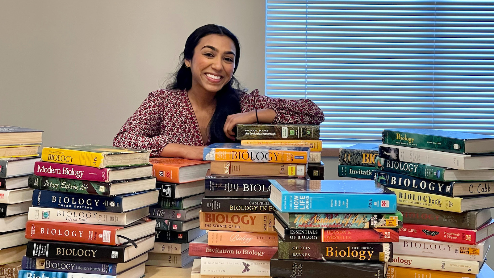 Rabiya Ansari sits with stacks of textbooks