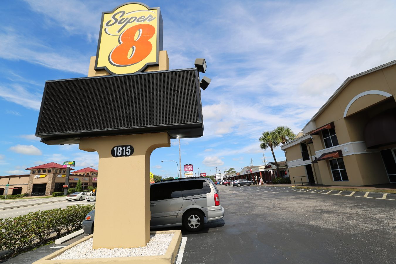 A view of a Super 8 motel sign from its parking lot on a sunny day in Kissimmee, Florida.
