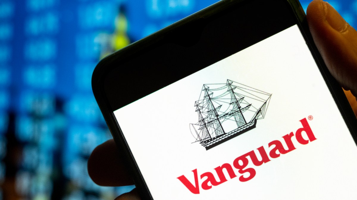 A photo illustration of a phone screen displaying the logo for the company Vanguard, which provides asset management and investing services.