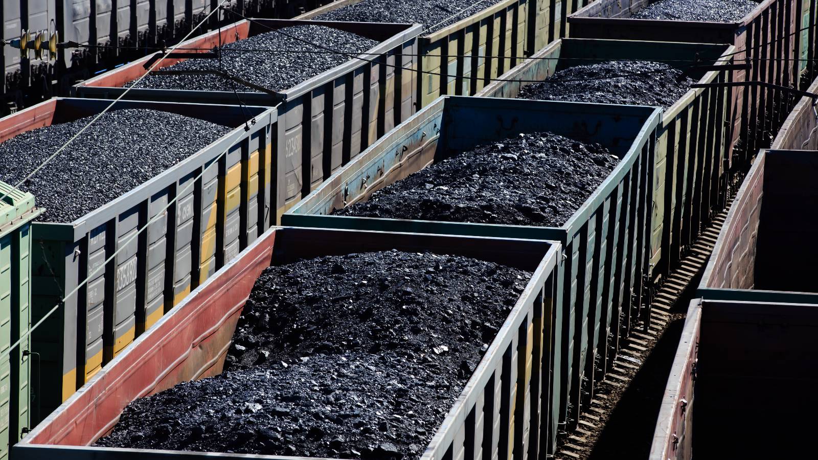medium shot of open rail cars full of coal