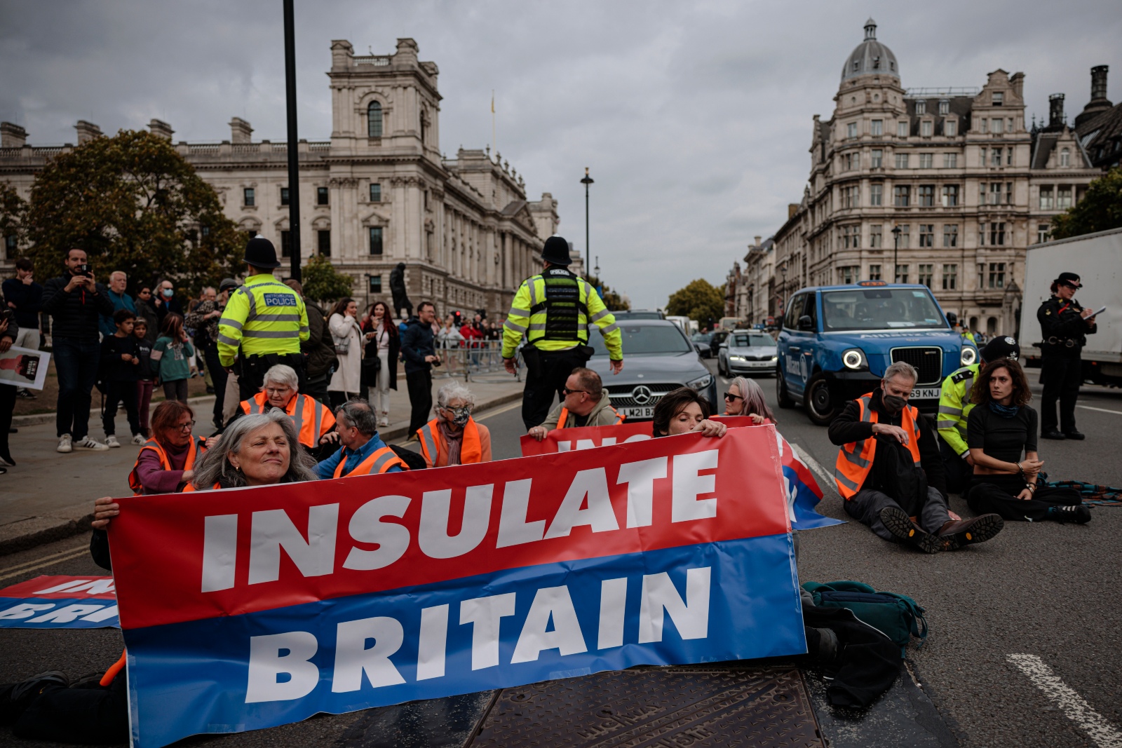 Demonstrators holding an Insulate Britain sign block traffic.