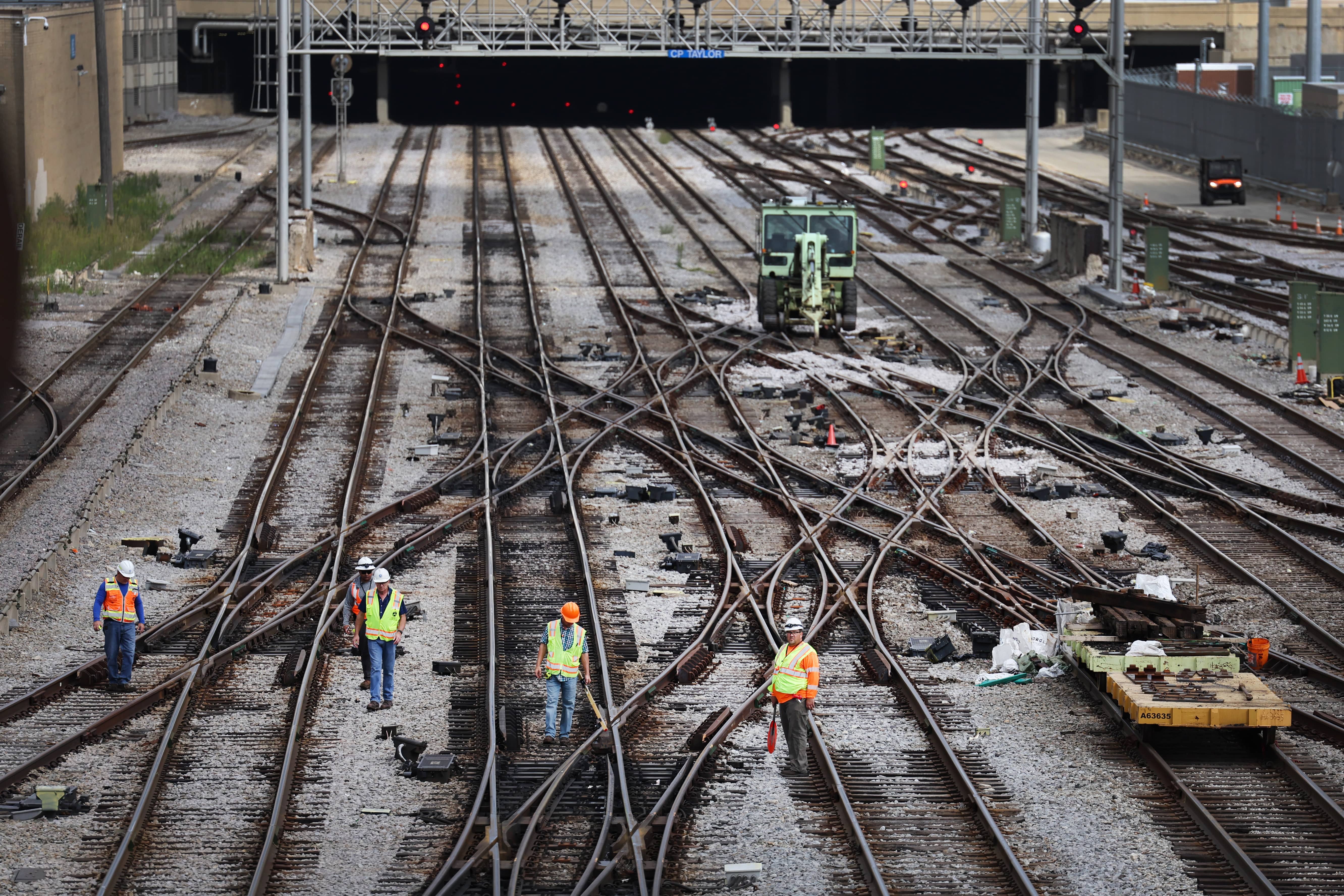 overhead view of workers standing on train tracks