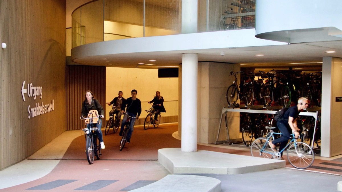 Cyclists ride in and out of a multi-story bike parking garage in Utrecht