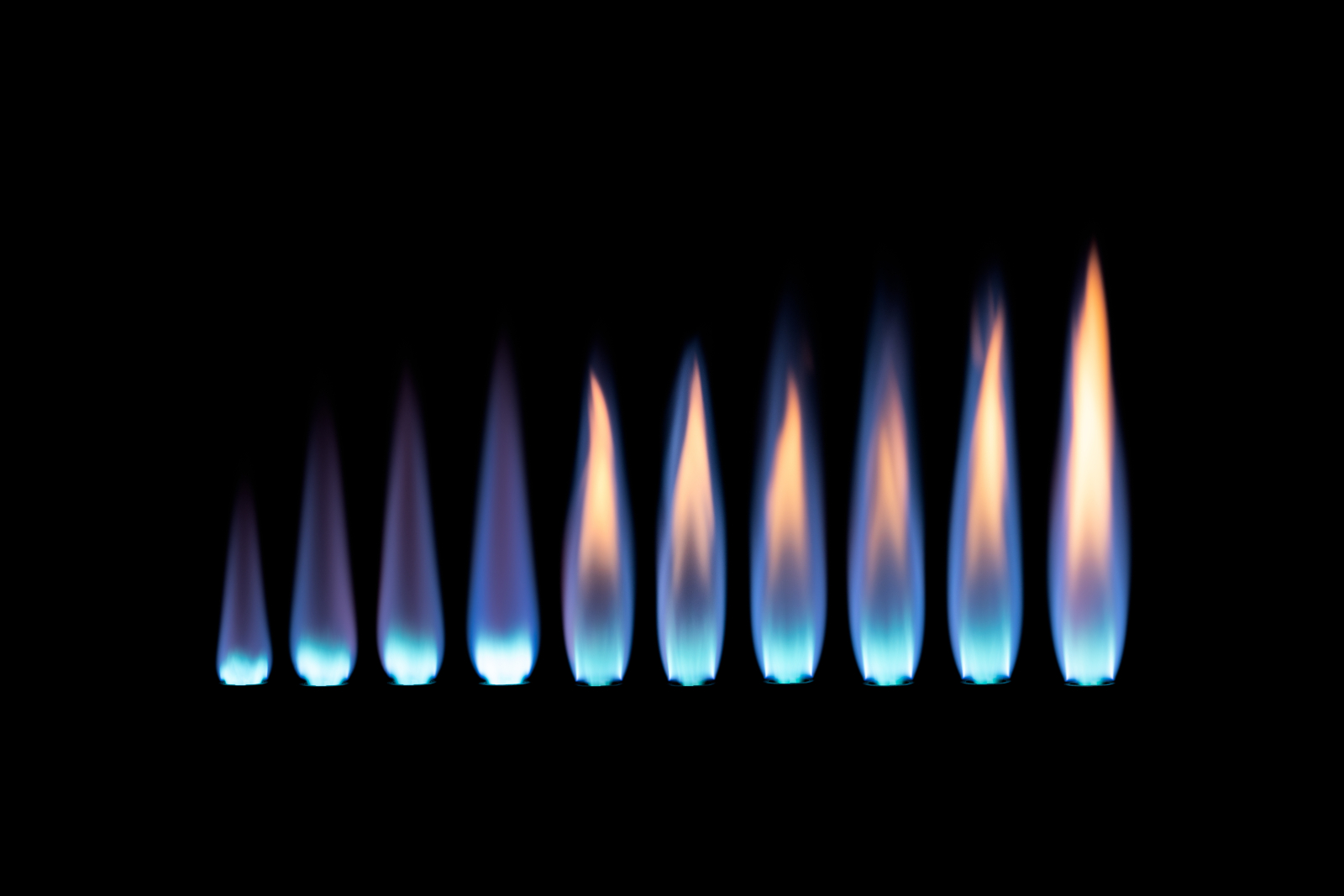 A blue flame gets large going from left to right against a black background.