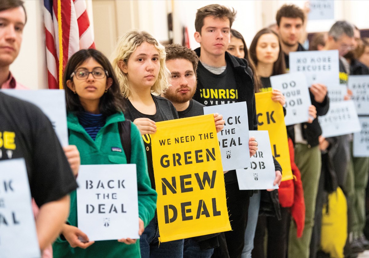 Protesters holding signs urging Democrats to support the Green New Deal