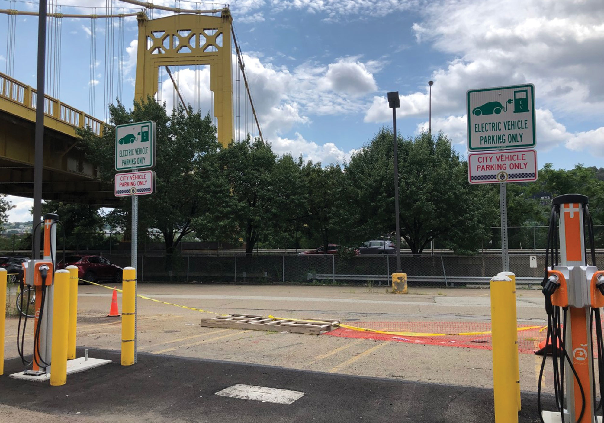 Parking spaces for electric vehicles with bridge in background