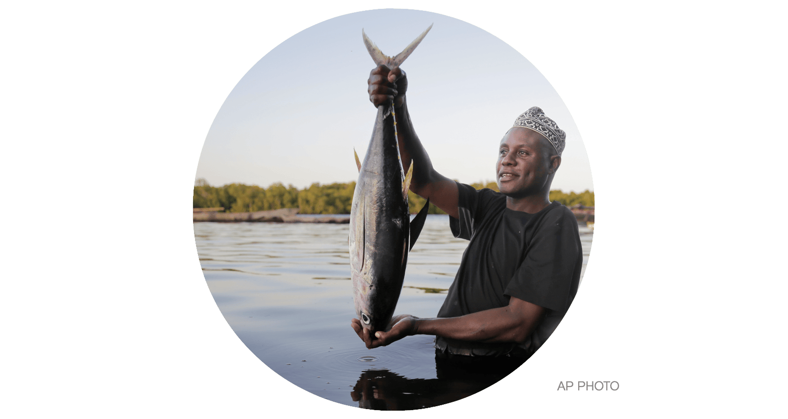Fisherman Kassim Abdalla Zingizi holds a yellowfin tuna after a catch in Vanga, Kenya