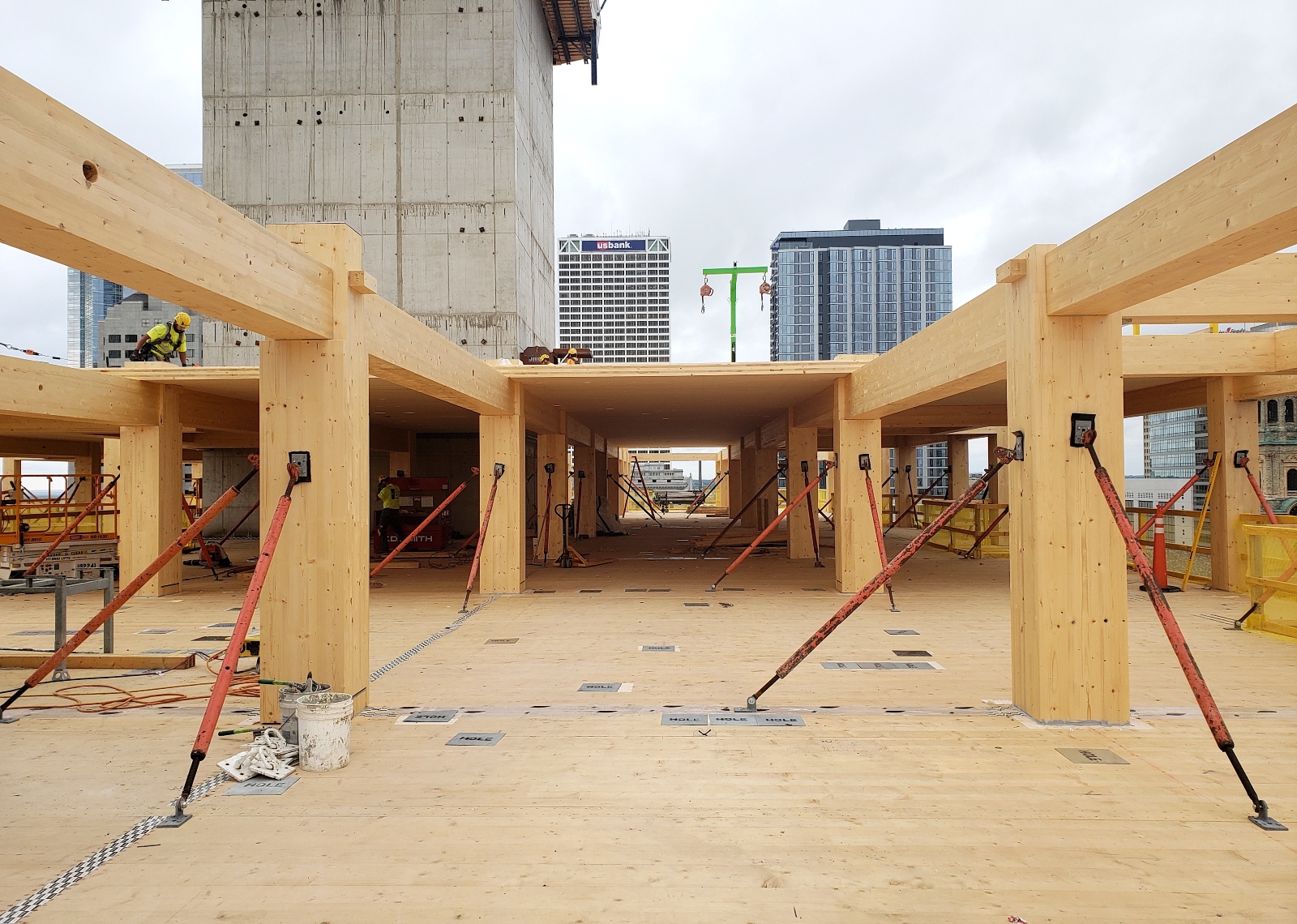 A construction site with all wood beams and flooring in the middle of a city.