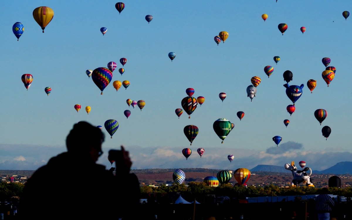 Dozens of colorful hot-air balloons float in the sky above Albuquerque, New Mexico.