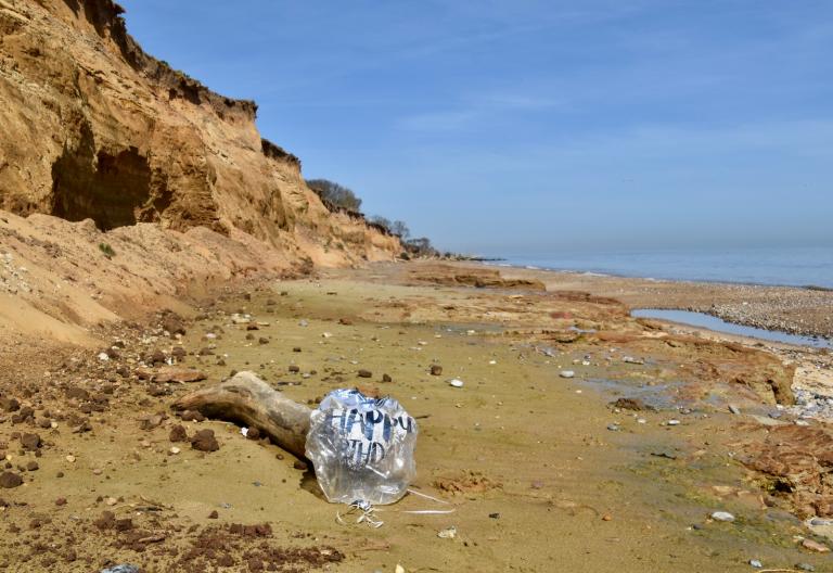 deflated birthday balloon on a beach