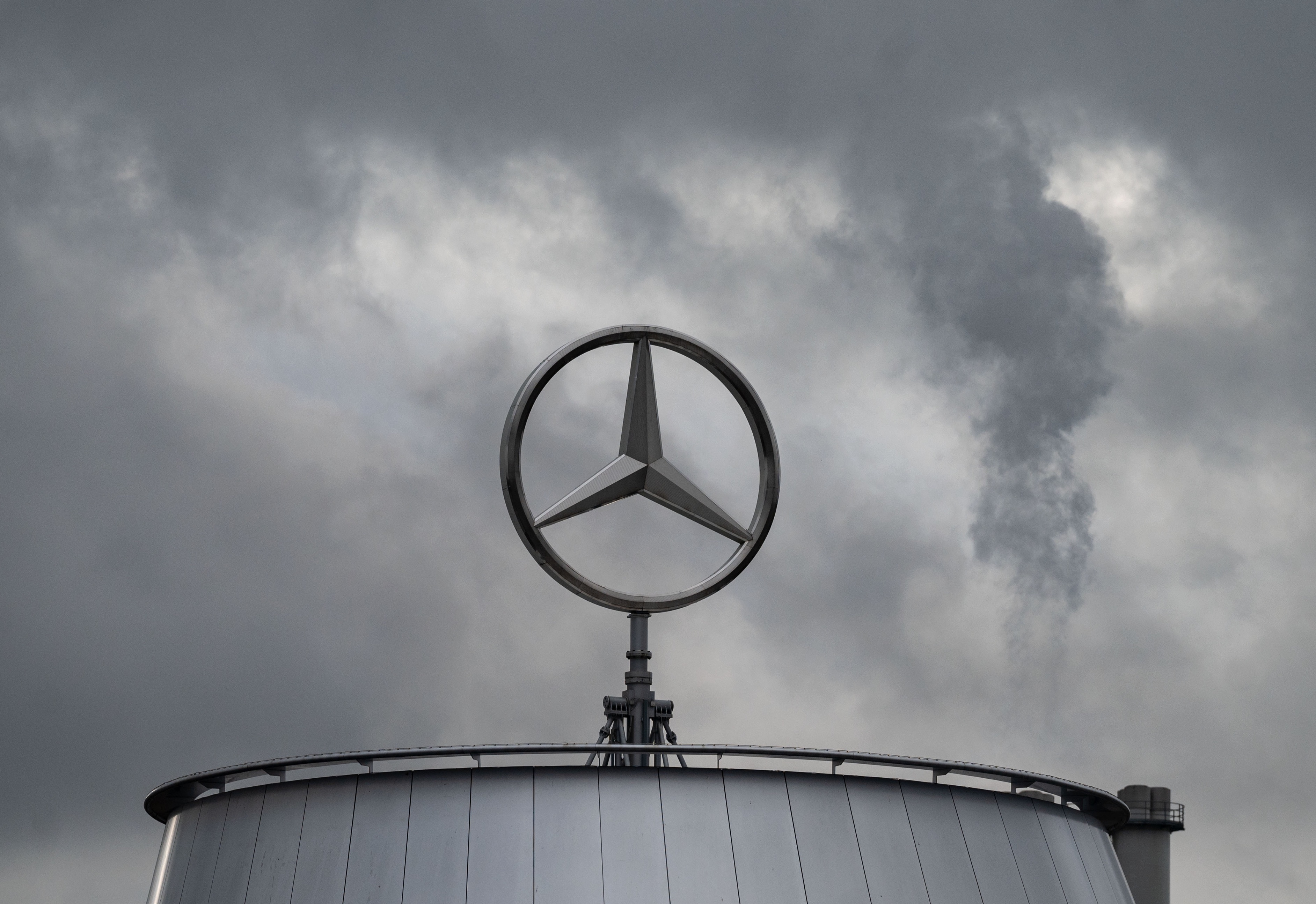 The Mercedes-Benz star against a cloudy sky