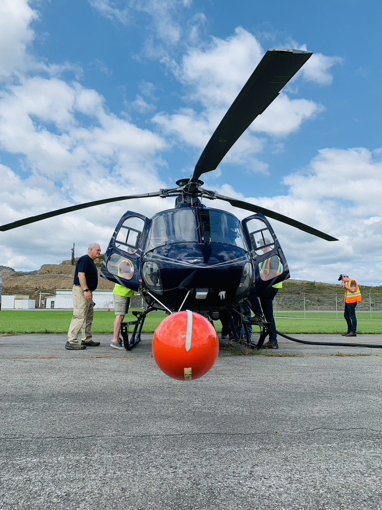 A helicopter with a boom carrying sensitive equipment for airborne geophysical research.