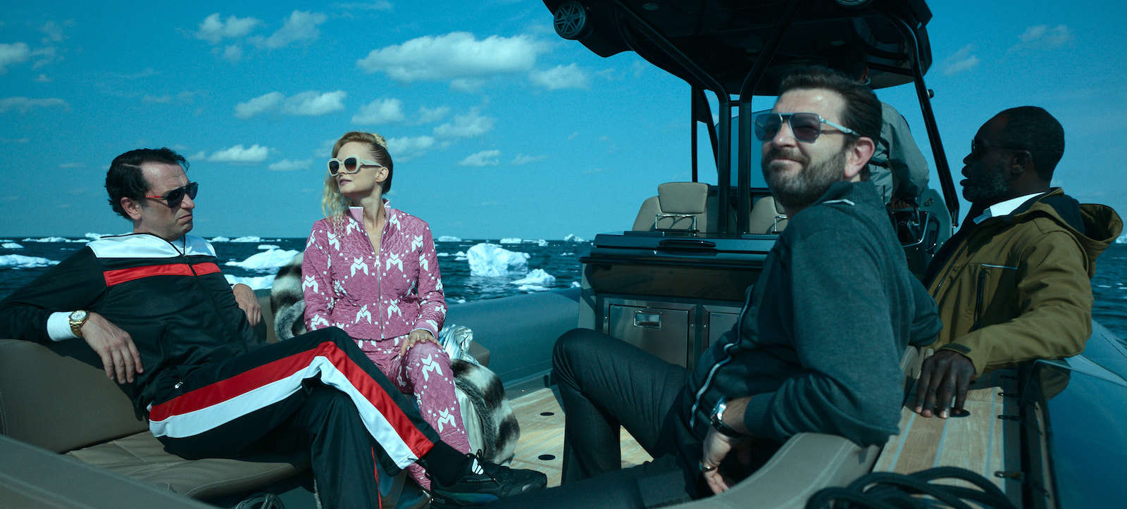 two men and a women dressed inexpensive athleisure clothing on a boat near ice floats