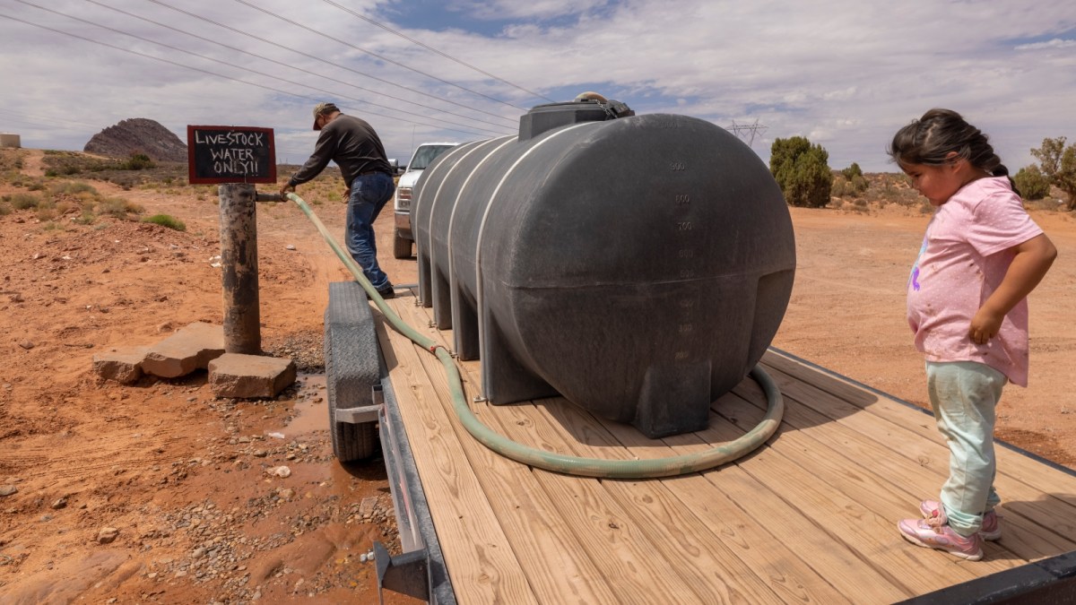 A man fills a water tank intended for drought-affected livestock from a community well on the Navajo Nation, south of Tuba City, Arizona.
