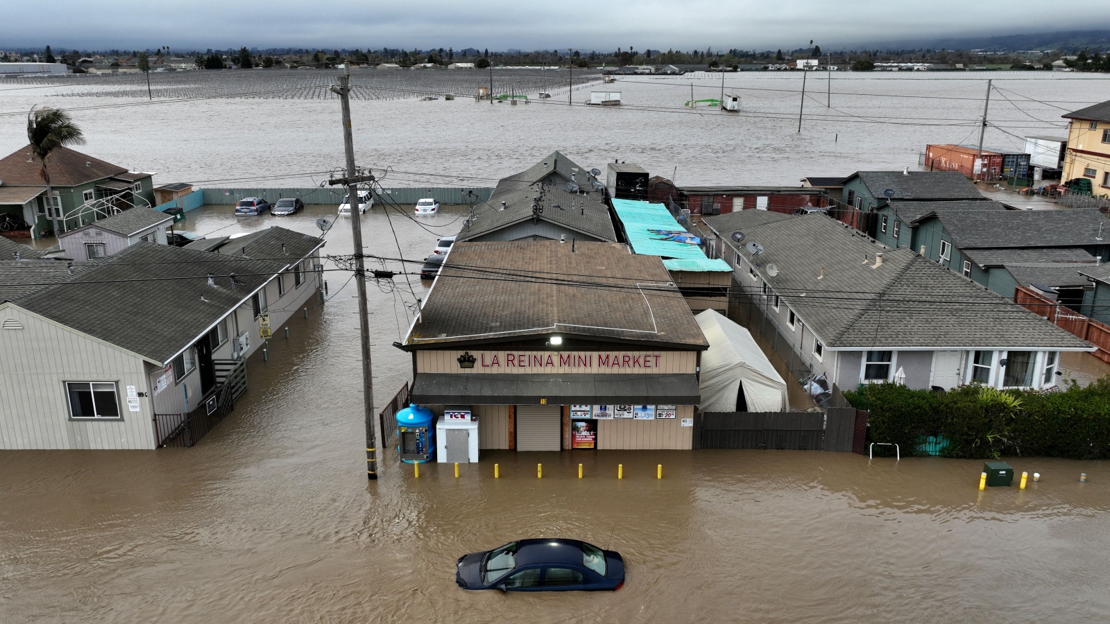 A car and market shop in floodwaters in Pajaro, California.