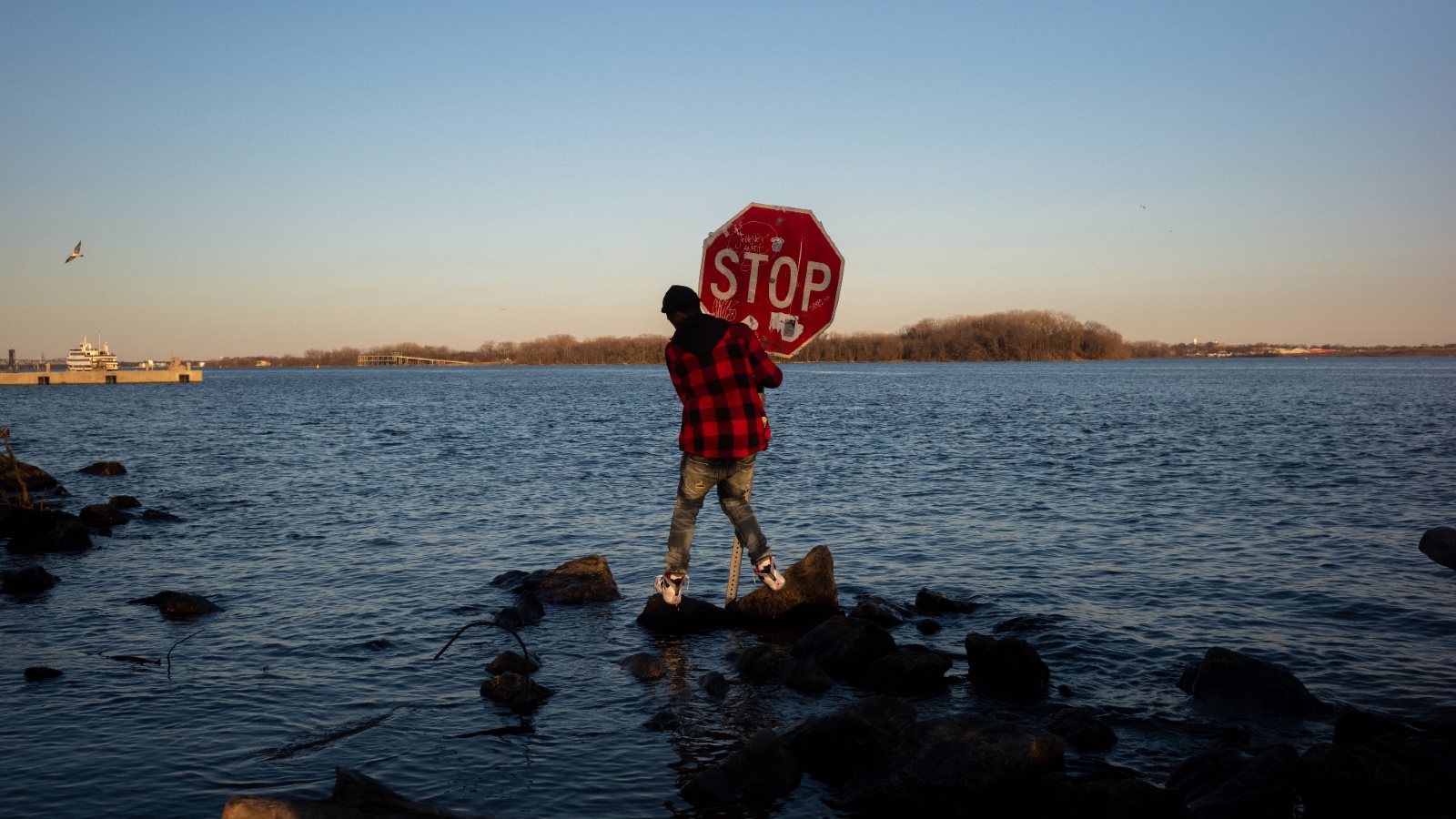 A person holds a stop sign that was placed in the Delaware River in Philadelphia following after a nearby chemical spill prompted concerns about the city's drinking water.