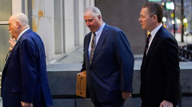 Three white men in suits entering a building; in the middle is Larry Householder, former Ohio House Speaker