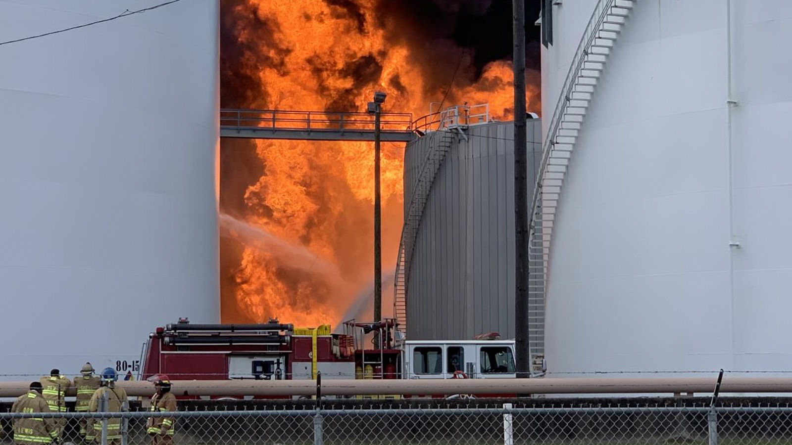 a large fire blazes between two large cylinders