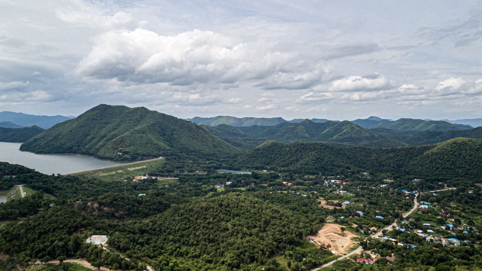 an aerial view of a forest with mountains