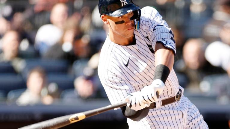 A man swings his bat at home plate in a baseball game.