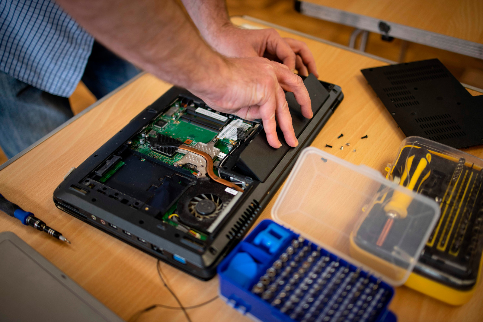 Damian Griffiths, director of Catbytes, a computer repair charity, repairs a donated computer at Ewart Community Hall in south London on February 15, 2021.