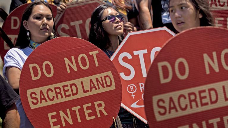 Members of the San Carlos Apache Nation and other activists holding signs reading "Do Not Enter; Sacred Land"