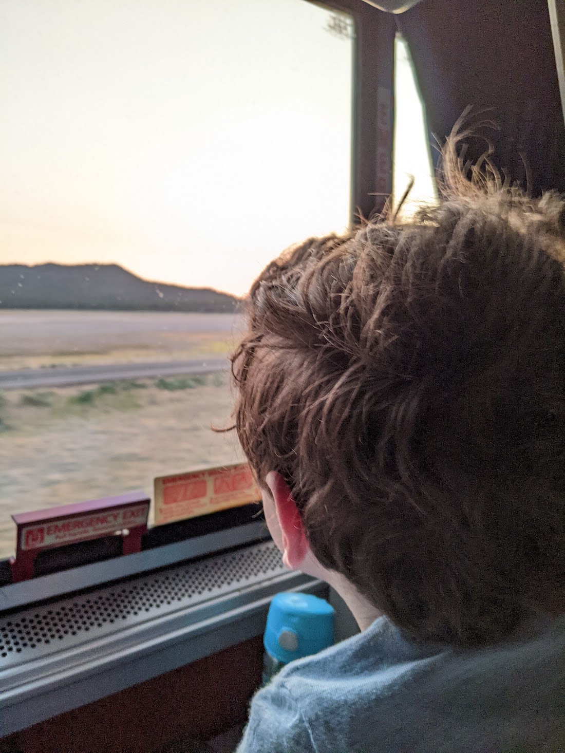 a boy looks out the window of a train and sees the ocean