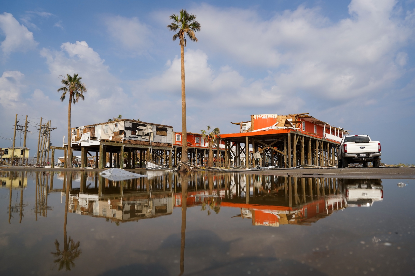 Storm-damaged houses are reflected in flood water after Hurricane Ida made landfall on Grand Isle, Louisiana. The storm destroyed thousands of homes and eroded sections of the coastline.