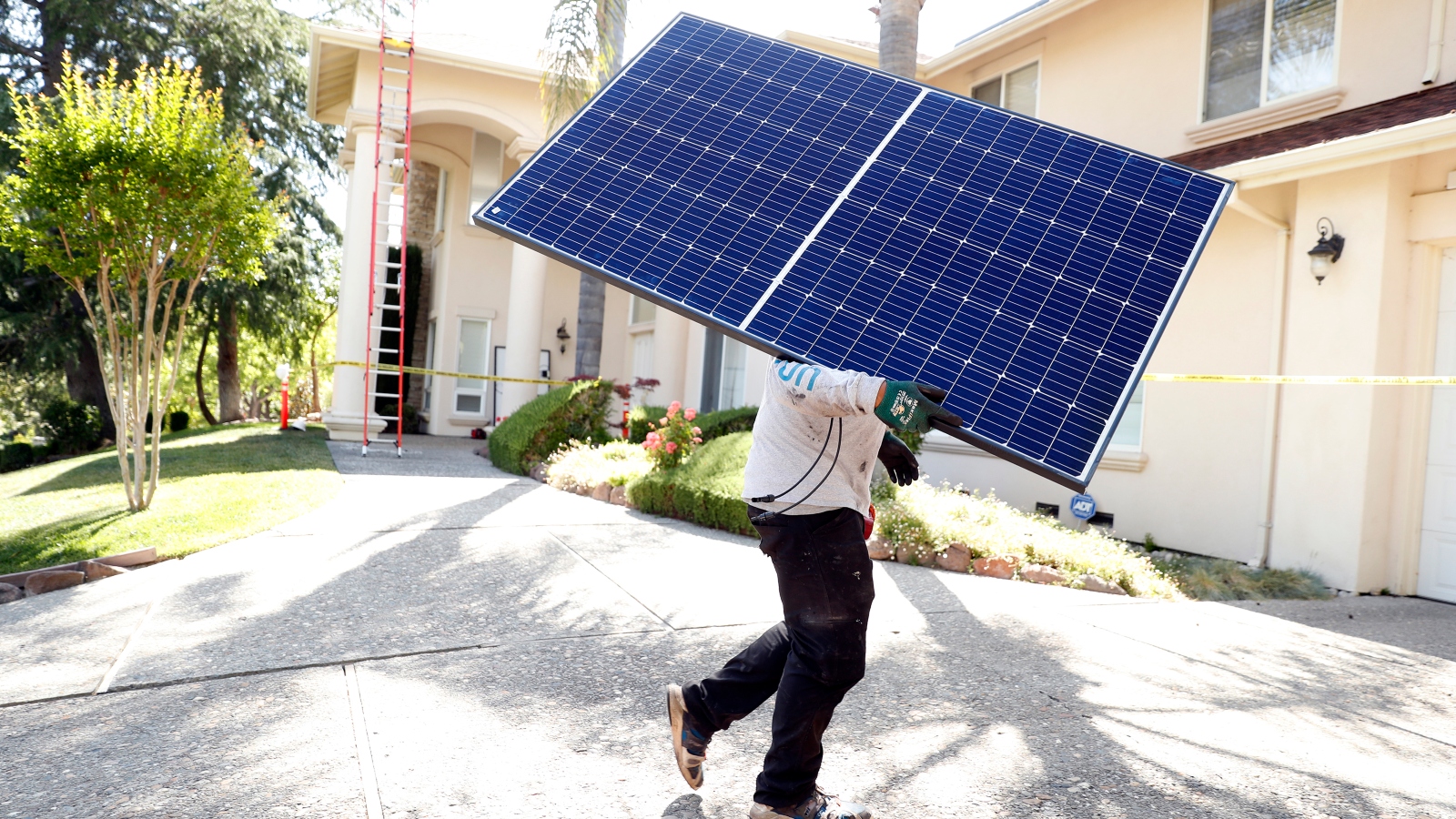 Sunrun employee Gonzalo Najera carries a solar panel before installation at a home in Alamo, Calif., on Monday, May 17, 2021.