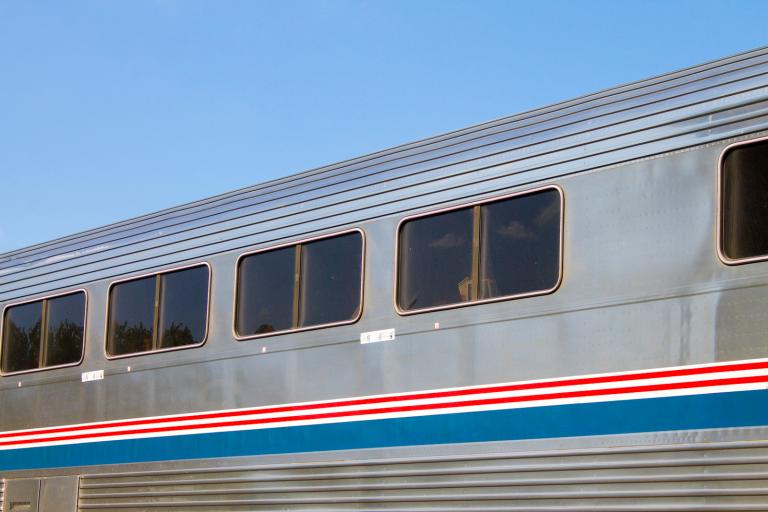 a silver train car with red and blue stripes