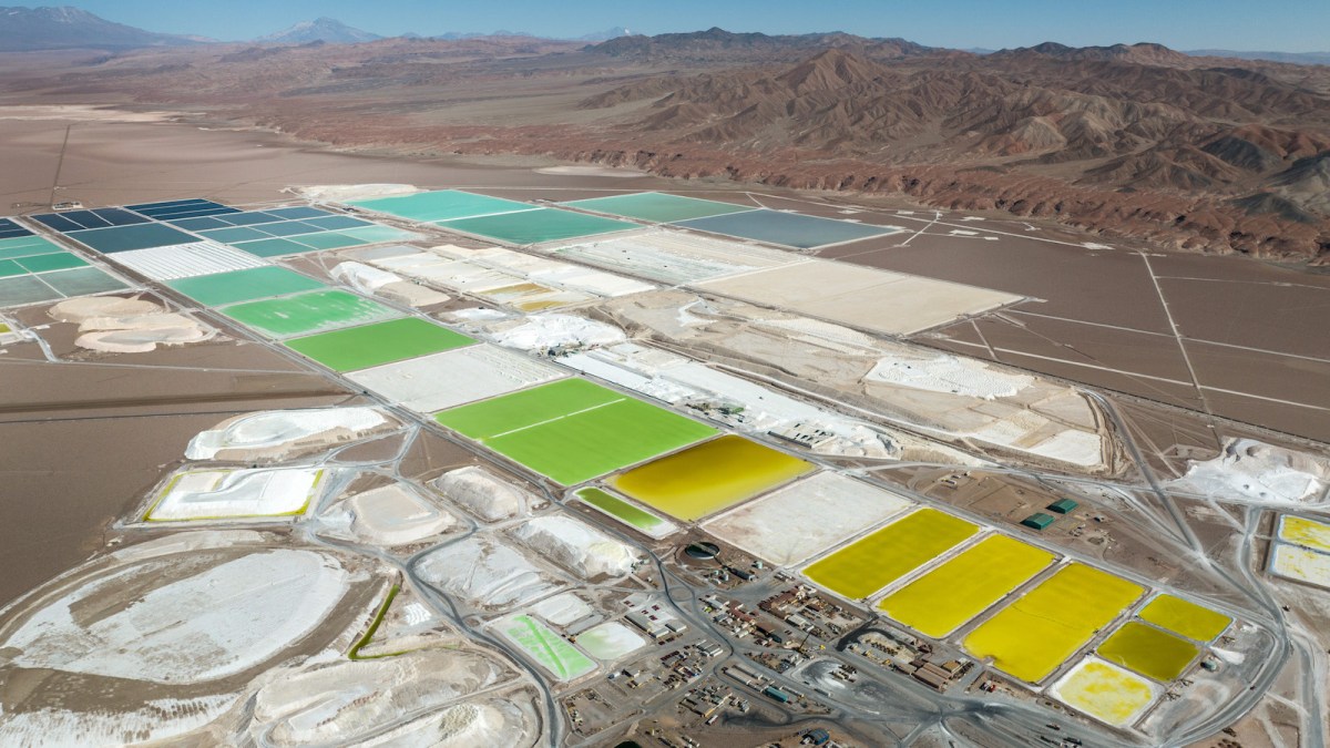 Aerial view of lithium mine evaporation ponds in the Atacama Desert (in Salar de Atacama, Chile) with mountains in the background