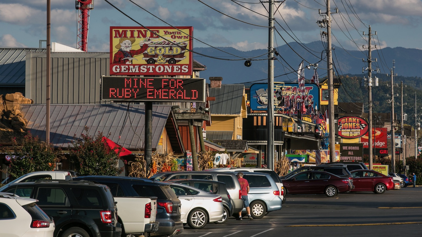 The main street in Pigeon Forge, Tennessee is packed with cars and lined with tourist attractions.