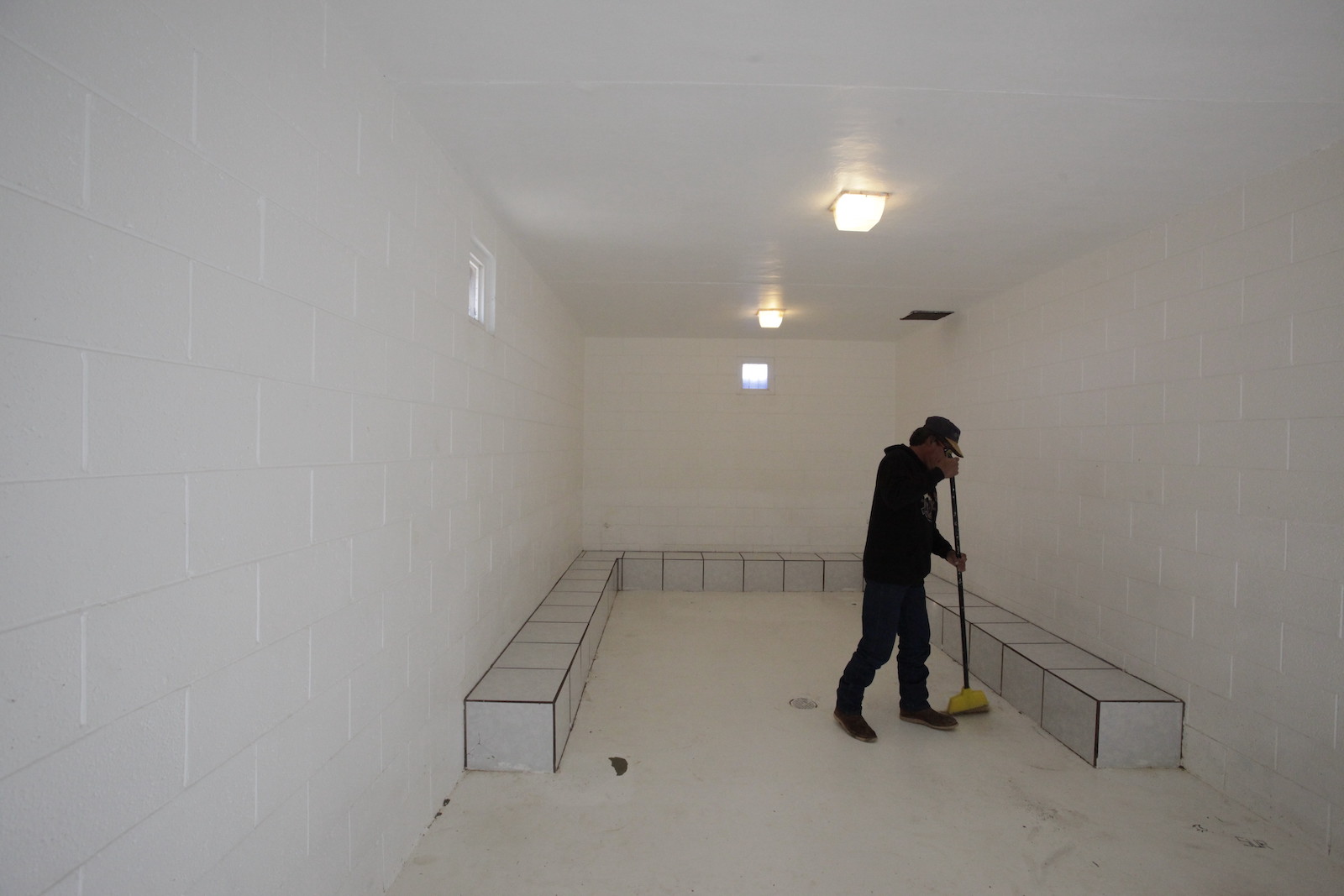 a person cleans a sparse room painted white