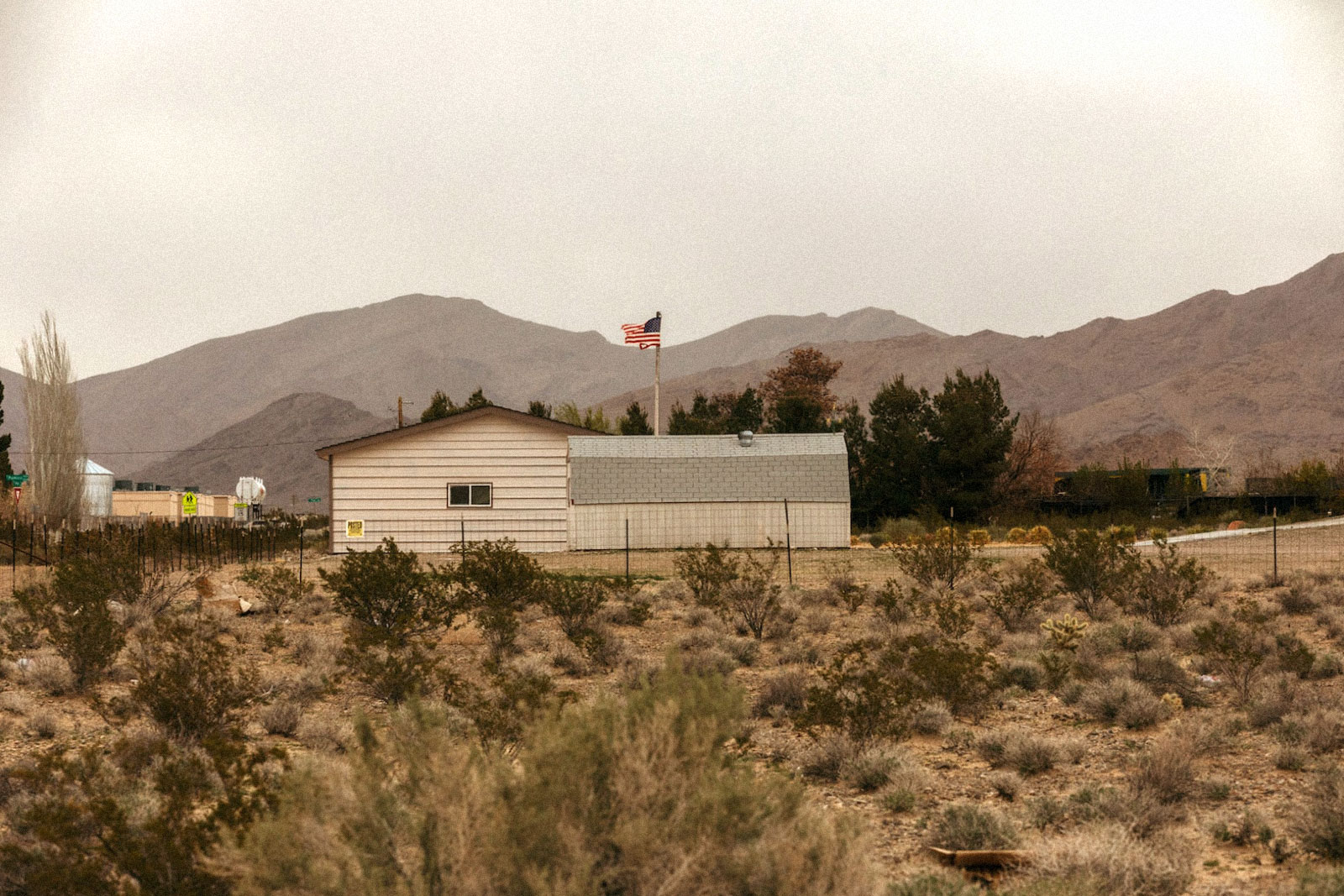 a house flying an American flag in a desert