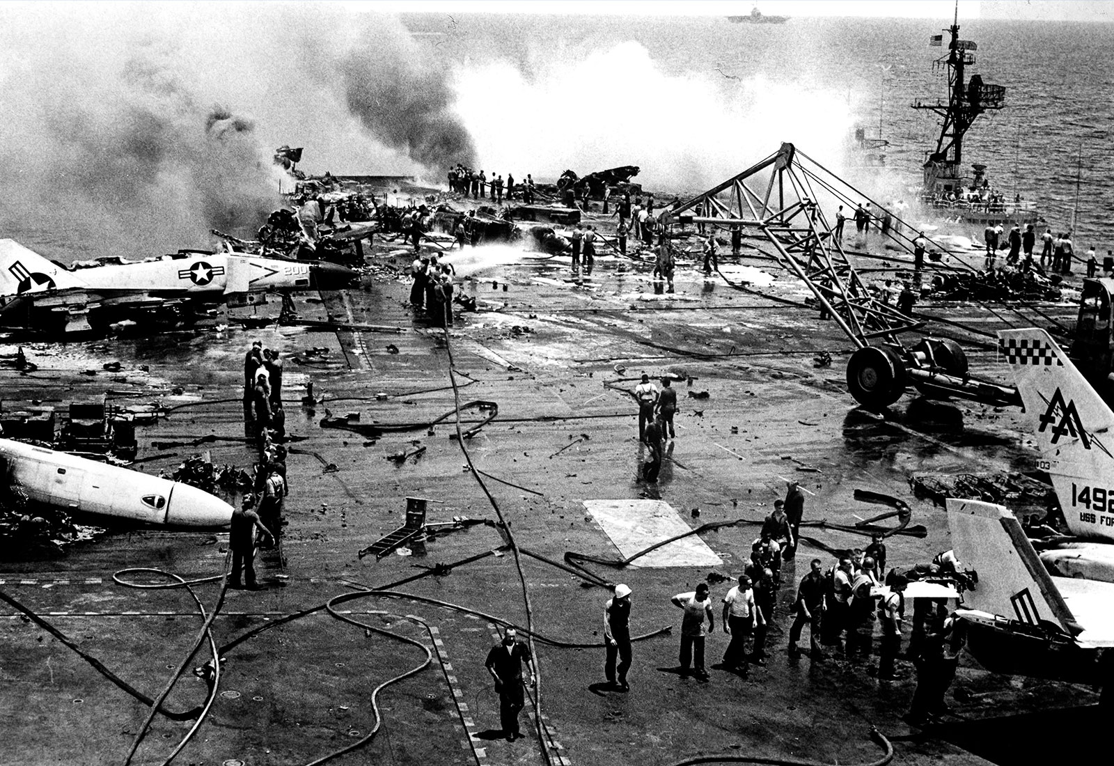 Crew works to extinguish rocket explosion aboard USS Forrestal in July 1967.