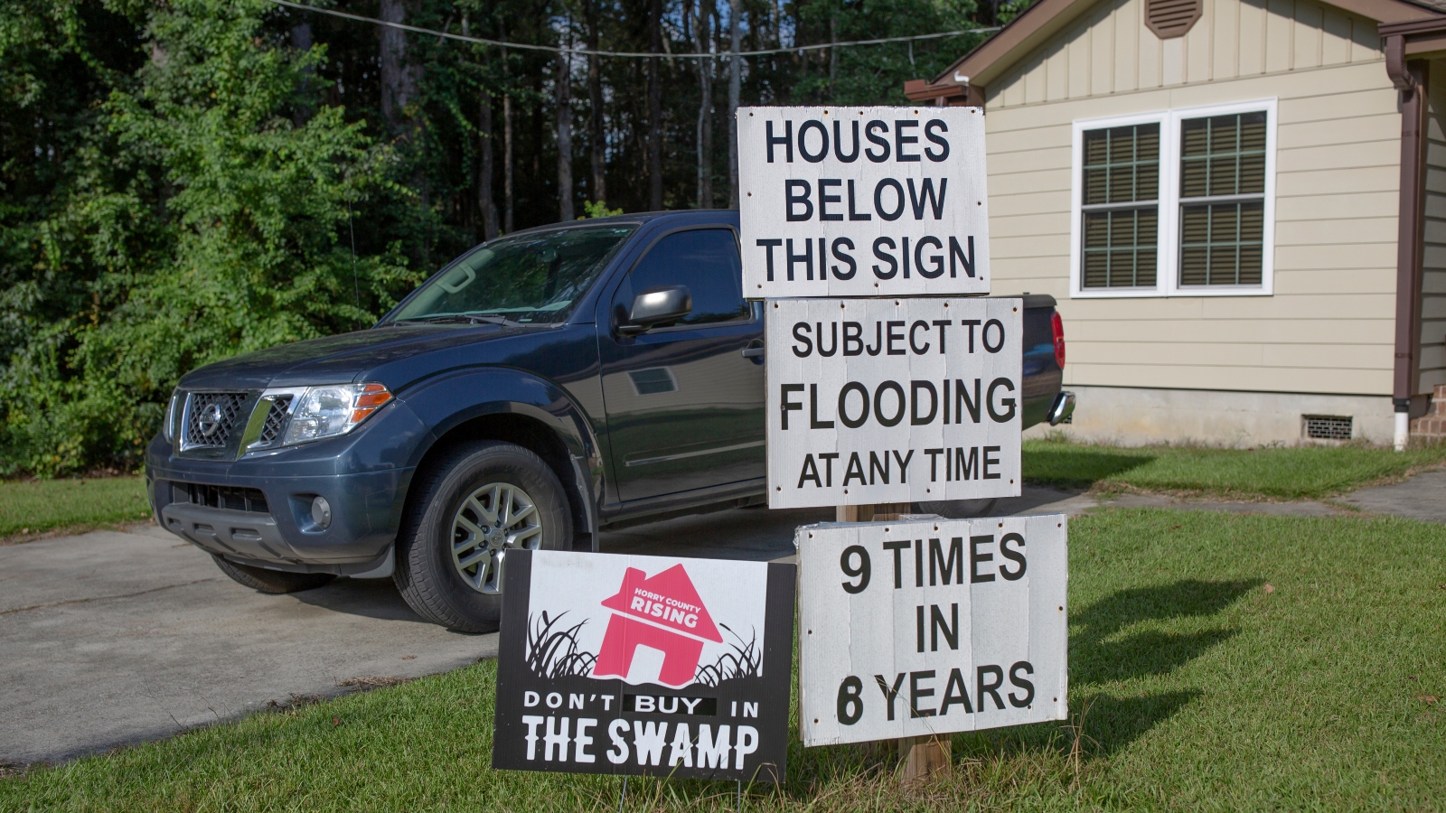 Signs warn potential homebuyers about flooding issues in Myrtle Beach, South Carolina.
