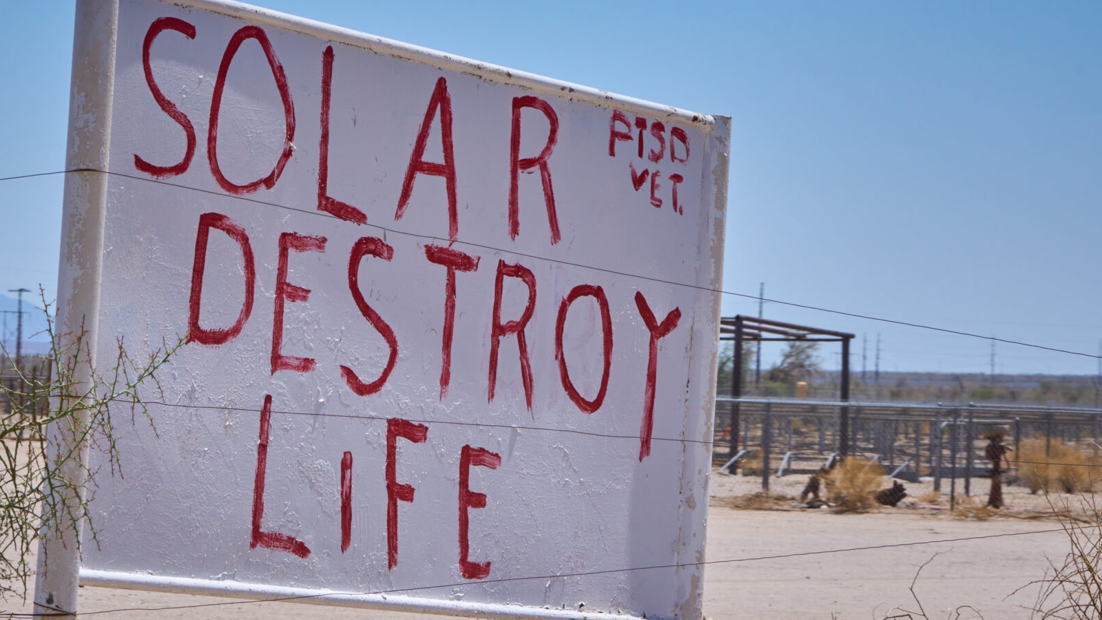 A sign that says Solar destroy life PTSD Vet in the desert.