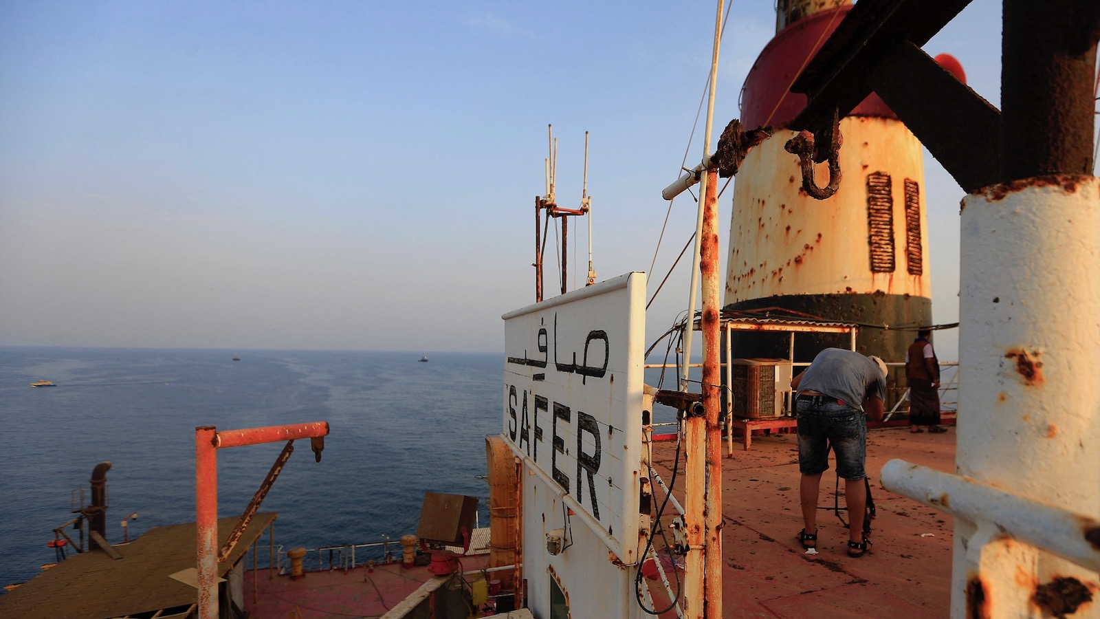 A crew member stands on the deck of the FSO Safer, a rusting and decaying oil tanker in the Red Sea