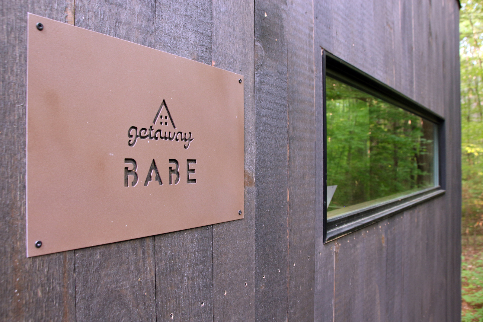 a plaque says babe on the wall of a tiny house