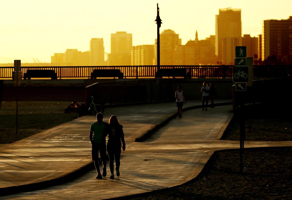 Beachgoers walk along the shore near the Belmont Pier in Long Beach in 2022, ahead of a heat wave in Southern California.