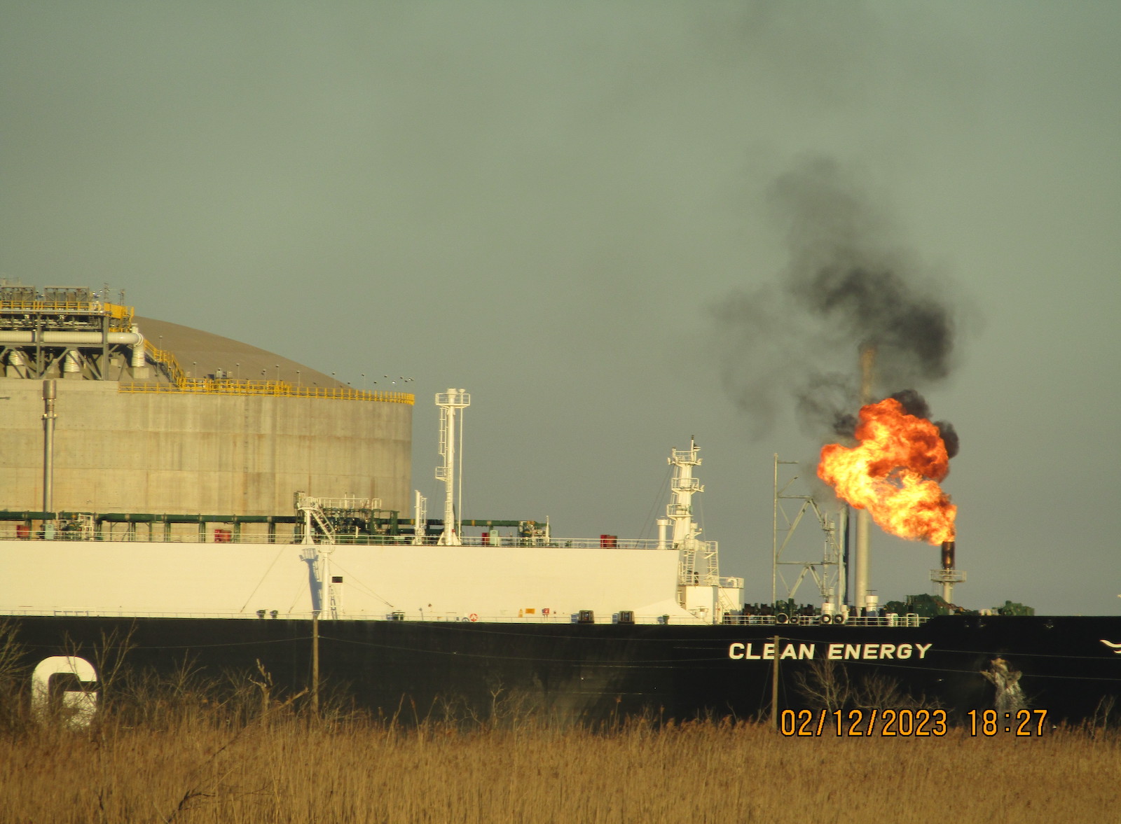 a giant fireball comes out of a stack near a ship called clean energy